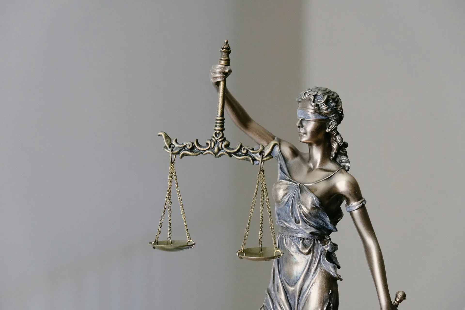 Bronze Lady Justice statue holding balanced scales
